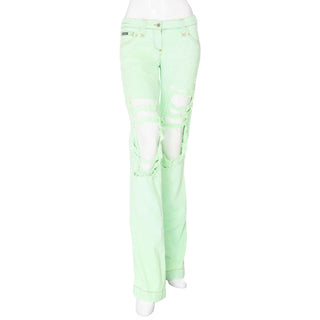 Dolce & Gabbana light green denim low rise bootcut jeans with distressed ripped front and rhinestone crystal D&G detail on back pocket, in Size IT 42, or an estimated waist size 27-28 inches. Available at designer and vintage specialty consignment shop "Decades" in Los Angles.