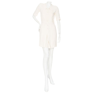 Preowned vintage 1970s cream pleated mini dress with short sleeves and a classic collar in Size FR 38, an estimated  US Size 6 or Small, by Yves Saint Laurent for Rive Gauche label. In very good vintage condition with some minor snags. Available for purchase online and in store at vintage specialty consignment shop Decades in Los Angeles. 